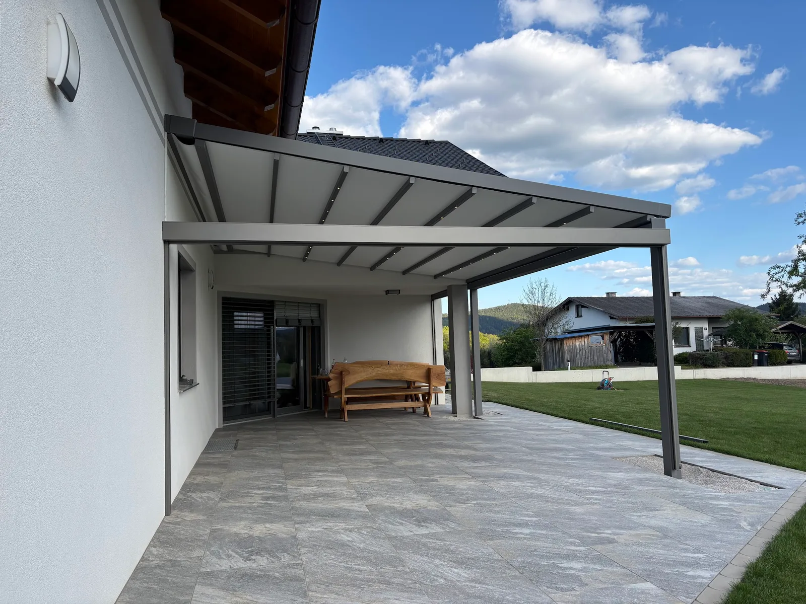 Graue Terrassenüberdachung mit integrierter Beleuchtung